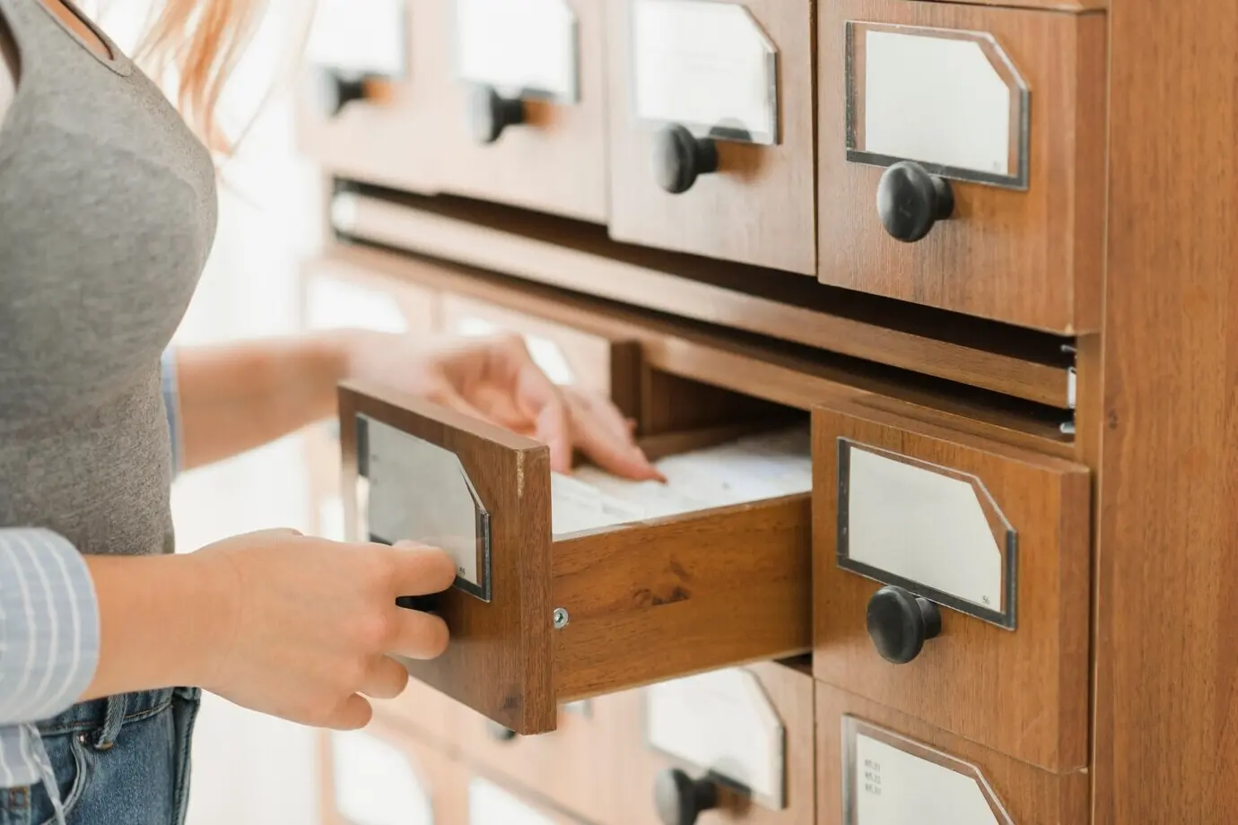 Обрезанный кадр библиотекаря, ищущего библиографическую запись.